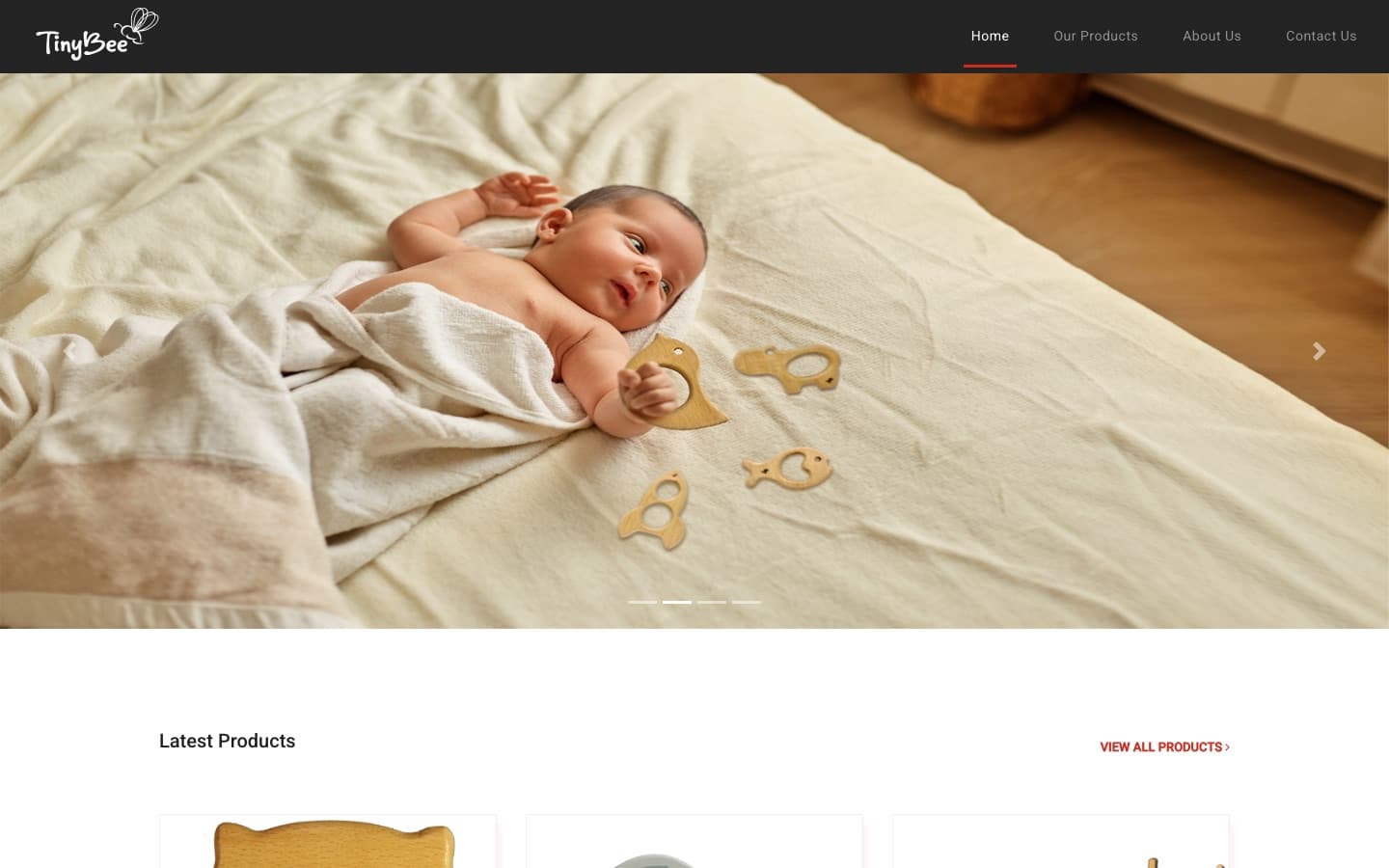 Tinybee home page — dark header with the TinyBee wordmark and primary nav, above a full-bleed hero carousel of a toddler playing with wooden toys, with a Latest Products grid below